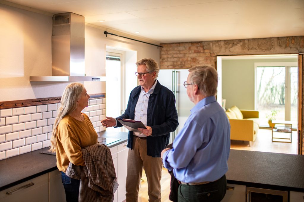 Sellers Senior couple looking at a house for purchase or lease with their real estate agent